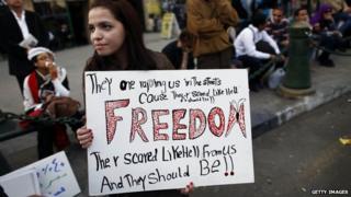 An Egyptian woman holds a banner as she marches in downtown Cairo to mark International Women's Day on 8 March, 2013