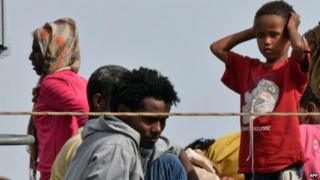 Мигранты высаживаются с итальянского военного корабля по прибытии в порт Августы на восточном побережье Сицилии (21 мая 2015 года)