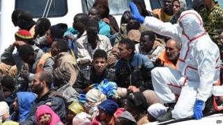An Italian Coast Guard ship carrying migrants arrives at Pozzallo's harbour near Ragusa, Sicily, Italy, Tuesday, May 19, 2014.