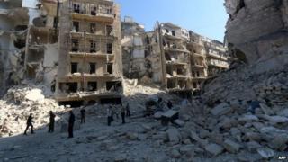 People look at destroyed buildings in Aleppo. Photo: 30 May 2015