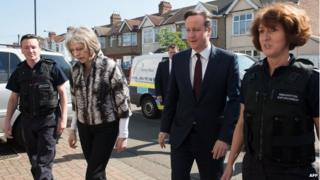 David Cameron and Theresa May with immigration enforcement officers following following an early morning raid on a home in London