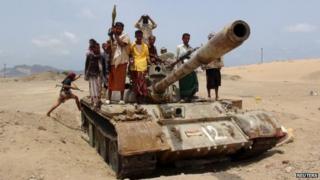 Fighters from the Southern Popular Resistance ride on a tank at the front line of fighting against Houthi fighters, on the outskirts of Yemen's southern port city of Aden (06 June 2015)