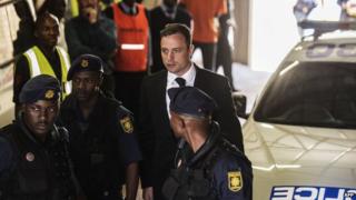 Oscar Pistorius is escorted to a police van after his sentencing at the North Gauteng High Court in Pretoria on October 21st 2014