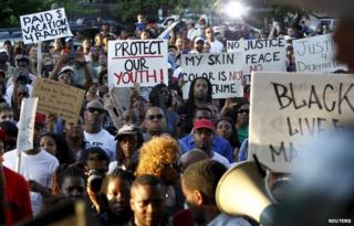 Protesters listen during a rally against what is being described as police brutality in McKinney, Texas June 8, 2015