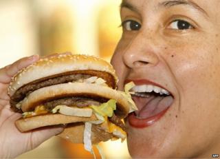 Девочка ест гамбургер в Макдональдсе в Мюнхене - файл фото