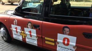 Такси с плакатом, изображающим отношения Убера с правительством