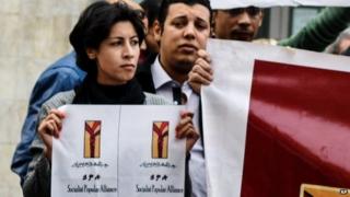 Activist Shaimaa al-Sabbagh holds up a poster at a protest in Cairo shortly before her death (24 January 2015)