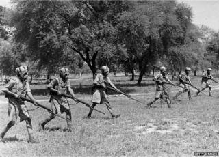 около 1940 года: индийские пехотинцы в противогазах надевают на себя свои тюрбаны во время учений по подготовке к дежурству во Второй мировой войне.