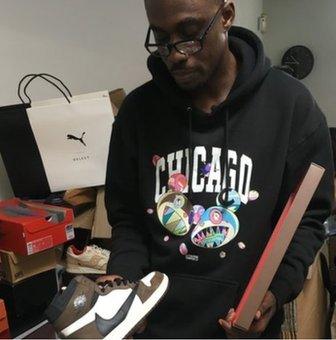 Franklin Boateng otherwise known as "The King of Trainers" holding a pair of Travis Scott Air Jordan 1 Hi OG trainers