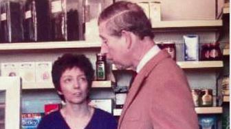 The King, who was Prince Charles at the time, wearing a brown coat and speaking to a woman in the shop at Hesket Newmarket