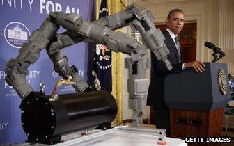 President Obama stands next to a robot