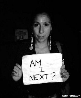 Woman holds "Am I next" sign?