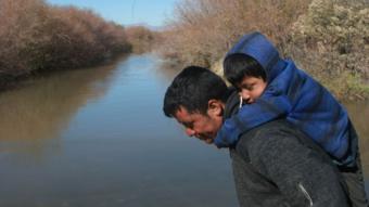 Una familia de migrantes trata de cruzar el Río Bravo.