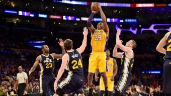 Kobe Bryant lanza la pelota entre tres rivales