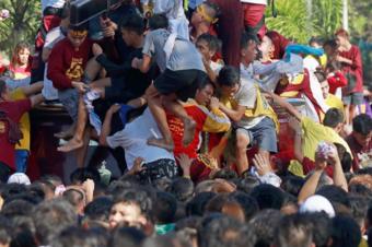 Catholics stand on each others' shoulders to try to touch the statue in Manila (9 Jan 2019)