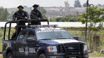 A unit of the Mexican Federal Police patrols the surroundings of the Puente Grande State prison (background) in Zapotlanejo, Jalisco State, Mexico, on 9 August,