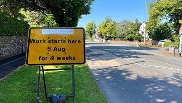 A yellow roadworks sign on Buxton Road, Leek