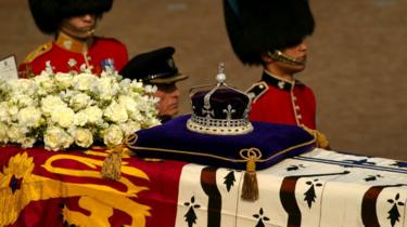 Une couronne incrustée de diamants portant le diamant Koh-I-Noor repose sur un cercueil portant la Reine Mère en avril 2002