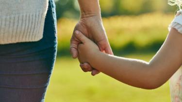 Child and parent holding hands