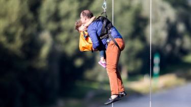 A man and a child are abseiled from a gondola over the Rhine in Cologne, western Germany, 30 July 2017