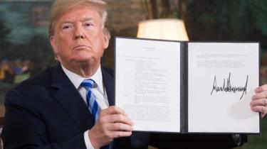 El presidente Trump sostiene un documento relacionado con la retirada de Estados Unidos del acuerdo con Irán