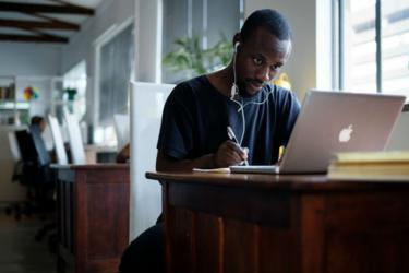 Young black South African sits at a computer