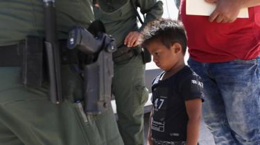 A small boy from Honduras waits as he and his father are taken into custody by U.S. Border Patrol agents near the U.S.-Mexico Border on June 12, 2018 near Mission, Texas.