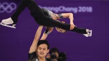 North Korea's Kim Ju Sik and North Korea's Ryom Tae Ok (top) compete in the pair skating short program