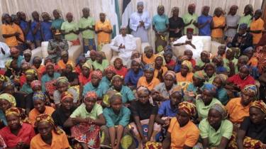 Uma das 82 raparigas Chibok libertadas encontra o presidente nigeriano Muhammadu Buhari (C) na Villa Presidencial em Abuja, Nigéria 07 de Maio de 2017