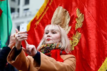 A woman takes a selfie with an image of Soviet state founder Vladimir Lenin.