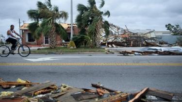 A man rides a bike among debris in Panama City, Florida. Photo: 10 October 2018