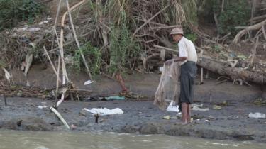affald ved siden af en flod i Myanmar
