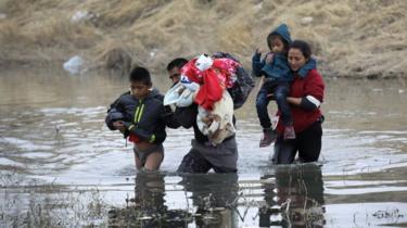 Inmigrantes cruzando un río