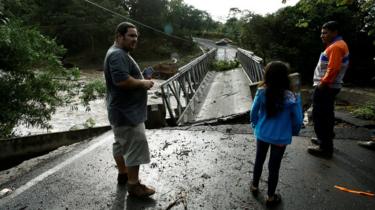 Menschen schauen auf eine vom Hurrikan Otto zerstörte Brücke in Guayabo de Bagaces, Costa Rica