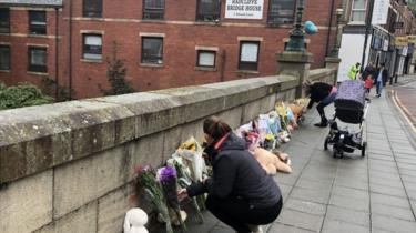 People leaving floral tributes