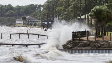 Waves crash against a home seawall in Eastpoint, Florida. Photo: 9 October 2018