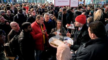 Passengers look at display boards and try to get delay information from German railway company Deutsche Bahn (DB) employees during a passing nationwide storm, at Cologne central railway station, Germany, 9 February 2020