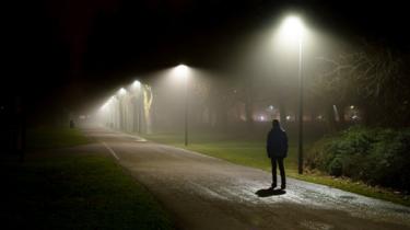 Hombre caminando en la noche oscura