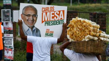 Apoiadores fazem campanha levando cartaz do candidato Carlos Mesa