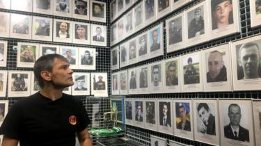 Survivor Roman Zinenko looks at a wall of victims of the battle of Ilovaisk