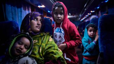 Malian migrants are transferred by bus to a temporary shelter upon their arrival in Bamako on December 13, 2017, after being repatriated from Libya by the IOM (International Organisation for the Migrations).