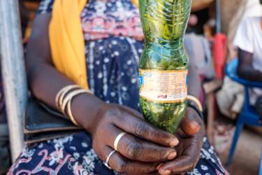 Een vrouw houdt een plastic fles gevuld met sprinkhanen