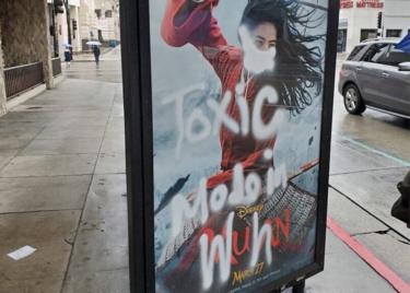 Um poster do filme Mulan desfigurado com graffiti - uma máscara é pintado em seu rosto, junto com as palavras "tóxico feita em Wuhan""toxic made in Wuhan"