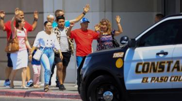 Shoppers exit with their hands up after a mass shooting at a Walmart in El Paso, Texas.