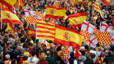 People hold Spanish and "Tabarnian" flags during a pro-unity rally organised by the Tabarnia movement, a fictional region that wants independence from Catalonia, on 4 March 2018 in Barcelona