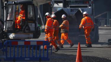 Construction workers work near the Excel Centre, London