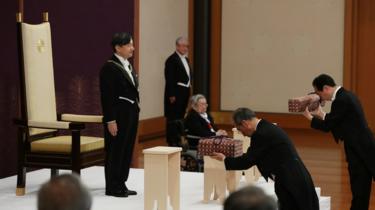 Japan's Emperor Naruhito, flanked by Prince Hitachi, attends a ritual called Kenji-to-Shokei-no-gi