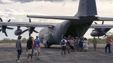Residents of McArthur River, a remote town in the Northern Territory, board a military plane during evacuations ahead of Cyclone Trevor.