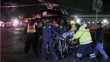 Emergency services transfer injured person to helicopter