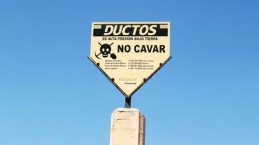 A sign warning of a pipeline is seen at the site where a fuel pipeline, ruptured by suspected oil thieves, exploded in the municipality of Tlahuelilpan, state of Hidalgo, Mexico January 22, 2019.
